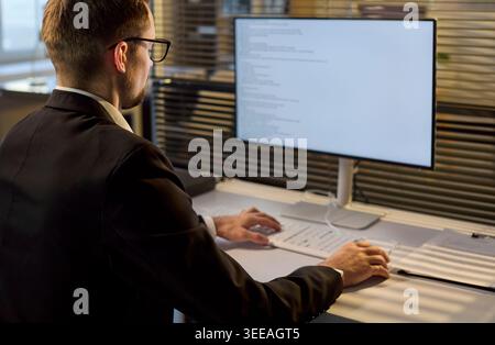 Business developer coding software on monitor in bright office workspace Stock Photo