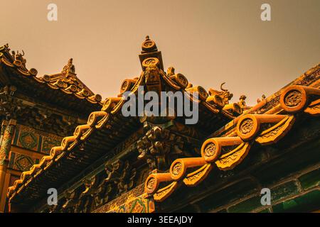Low angle view of traditional Chinese imperial roof corners with golden glazed tiles, ridge ornaments and dougong bracket sets Stock Photo