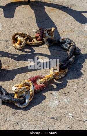 Old rusty anchor iron ship chain and the shadow of the anchor on the ground. Gataxidy, Greece Stock Photo