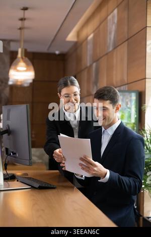 Receptionists working together on daily reports and documents in reception Stock Photo