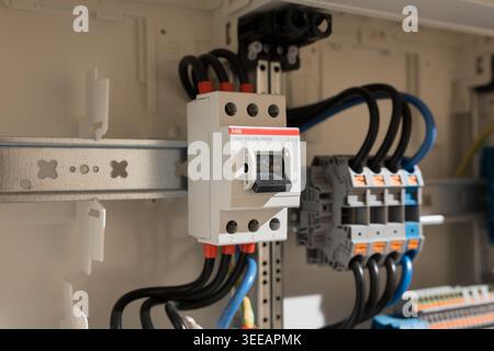 ABB E463 3KB main switch in domestic fuse box. On-off switch mounted on DIN rail. Close-up of electrical component in housing technology. Stock Photo