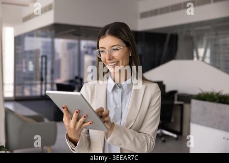 Smiling professional woman working on tablet device Stock Photo