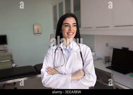 Smiling female doctor posing in examination room of medical office Stock Photo
