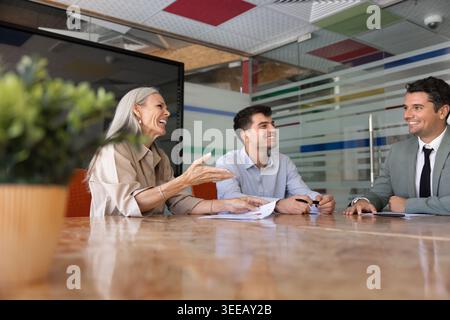 Positive multiethnic businesspeople engaging in professional discussion in conference room Stock Photo