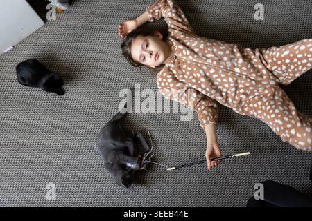 Girl and two kittens relaxing on floor Stock Photo