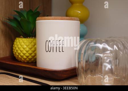 Coffee jar and plants on shelf in kitchen area Stock Photo