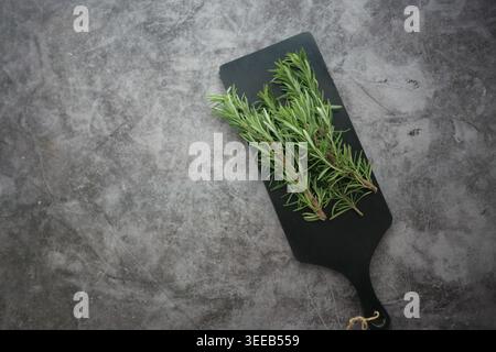 Fresh rosemary on a cutting board in the kitchen Stock Photo