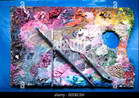 Paintbrushes and palette-knife on the palette for mixing oil paints Stock Photo