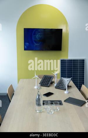 Long light-wood conference table is displaying wind turbine models and solar panels in meeting room Stock Photo