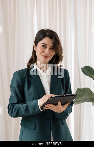 Businesswoman smiling while using digital tablet technology Stock Photo