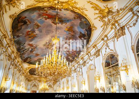 Gilded rococo stucco, ceiling frescoes and candle chandeliers line the ...