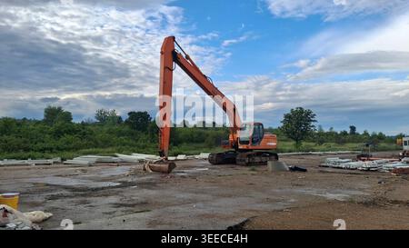 Doosan Daewoo Long-Reach Crawler Excavator Parked on Construction Site with Precast Concrete Elements Stock Photo