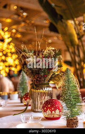 Festive and elegant Christmas table decoration in a cozy restaurant setting with warm golden bokeh background Stock Photo