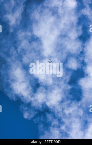 Airplane flying through soft clouds, with a dramatic sky and a sense of motion and altitude. Stock Photo