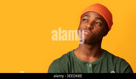 Closeup Shot Of Doubtful Black Young Guy Looking Aside At Copy Space Stock Photo