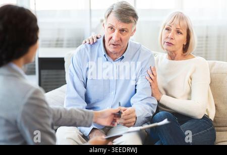Senior couple talking to financial advisor at home Stock Photo