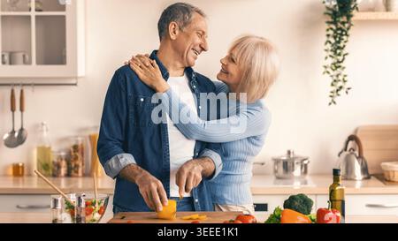Couple Cooks Together in a Kitchen While Preparing Fresh Ingredients Stock Photo