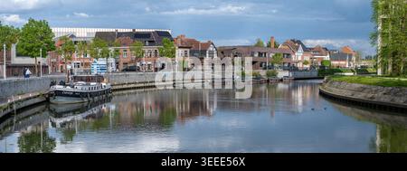 Colorful panorama over boats and apartment buildings along the River Leie in Deinze, East Flanders. The waterfront combines leisure boating with moder Stock Photo