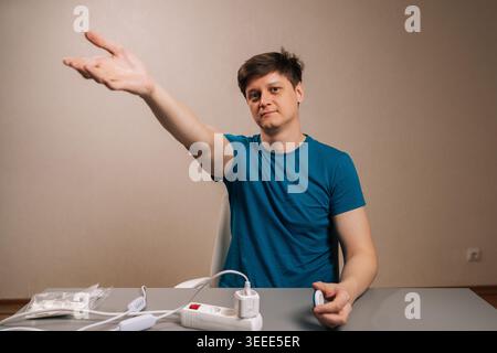 Portrait of man reaching out interacting with smart home automation, extending arm to control modern electrical devices, using wireless technology for Stock Photo