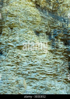 A rocky surface displays various layers and textures on a vertical cliff. The scene shows the effects of weathering and the passage of time in the wil Stock Photo