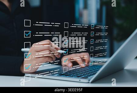 Digital checklist form and online survey task management concept. Person using laptop with check boxes, completed tasks, workflow approval, compliance Stock Photo