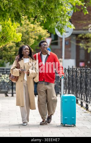 Happy relaxed african american man and woman couple travelers exploring new city on weekend trip. Stock Photo