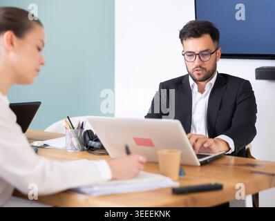 professionals working in a successful company, sit at a table Stock Photo