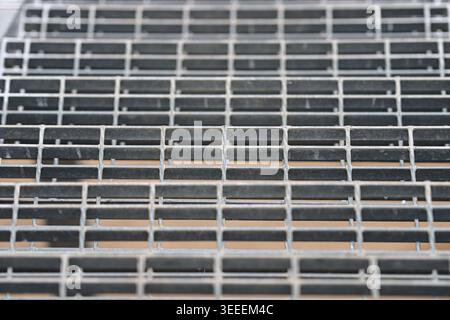 Industrial steel grating pattern with geometric metal texture representing engineering and urban structure. Stock Photo