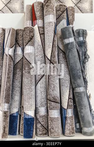 Rolled decorative carpets and modern rugs displayed in home improvement store Stock Photo
