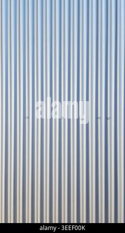 Full frame shot. Clean corrugated metal cladding with subtle light gradation. Even pattern, uniform texture ideal for backgrounds and industrial desig Stock Photo
