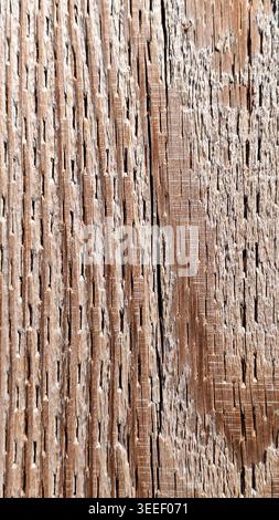 Detailed close-up shows worn wooden planks featuring tight, vertical grooves.  Texture, warm brown hue, and weathered surface evoke rustic charm and r Stock Photo