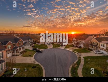 A drone aerial photograph captures a residential cul-de-sac in Clarksville, Howard County, Maryland, under a spectacular orange and red sunset sky. Th Stock Photo