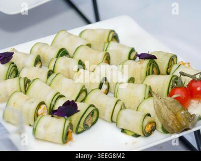 Assorted gourmet vegetable appetizers with tartines and zucchini rolls served as elegant finger food on a catering buffet table. Stock Photo