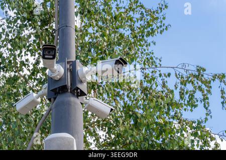 Four outdoor IP surveillance cameras on a metal pole. Security monitoring Stock Photo