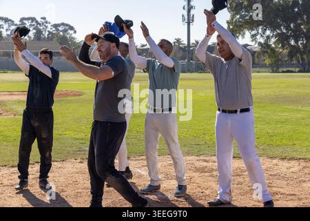 Baseball teammates raising caps on dirt after play, animating lineup and stats floating above field Stock Photo