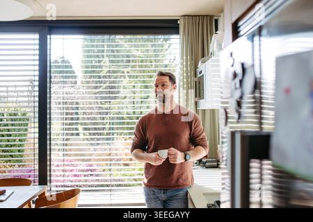 Man preparing coffee in modern kitchen at home. Stock Photo