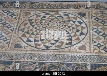 Close view of a circular geometric mosaic medallion made from stone tesserae at the Archaeological Museum of Dion in Pieria, Greece. Stock Photo