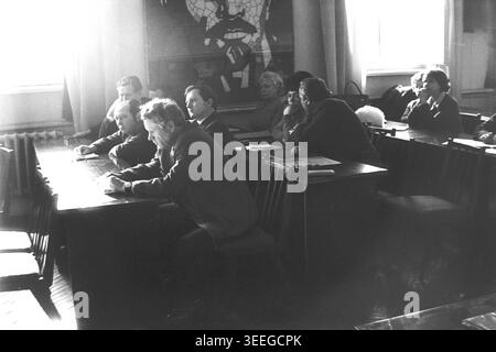 Slaviansk, 1983. Conference hall of the Armature-Insulator Factory (AIZ). A side view of the audience, showing men and women sitting at wooden desks and listening attentively during a factory event. This vintage black and white photograph captures the authentic atmosphere of the era, reflecting the daily activities and industrial culture of the region during the Soviet period. It serves as a valuable historical document of the local community, preserving the visual memory of the people and their everyday lives, showcasing a peaceful Donbas. Stock Photo