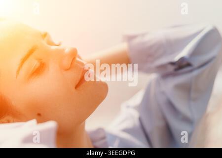 Woman relaxation sunshine serene young woman rests with closed eyes in warm light enjoying a peaceful moment of mindfulness Stock Photo