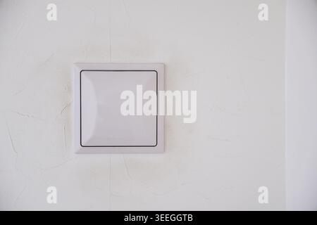 A white ventilation grille centered on a textured white interior wall. Clean minimal composition ideal for interior design, real estate, and home content. Stock Photo