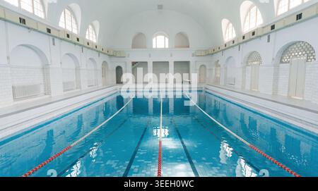 A magnificent, restored historic swimming pool from the German Imperial era, with a basin filled to the brim with crystal-clear, turquoise-blue water Stock Photo