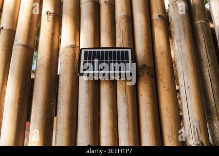 Small solar light mounted on bamboo wall eco friendly outdoor lighting Stock Photo