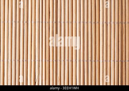 A close-up view of a woven bamboo mat showcasing its natural texture and repeating vertical pattern, perfect for backgrounds Stock Photo
