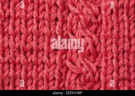 Detailed view of a chunky knit textile showing intricate cable patterns and the natural texture of the wool fibers Stock Photo