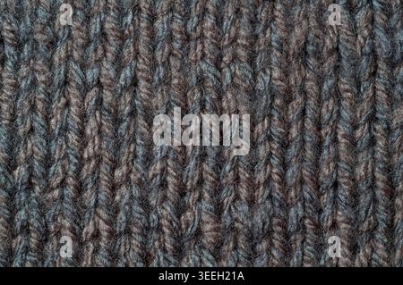Detailed view of a thick, cozy wool knit pattern featuring alternating strands of deep brown and muted grey fibers creating a rich texture Stock Photo