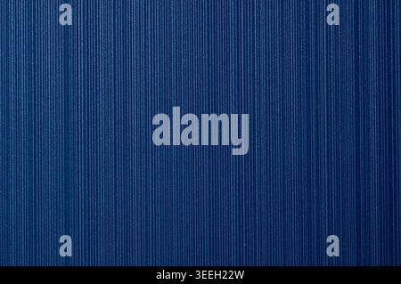 A close-up view of a dark blue surface featuring a repeating vertical ribbed texture with a matte finish and slight shimmer Stock Photo