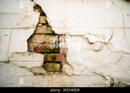 Broken stucco and worn, mossy bricks Stock Photo