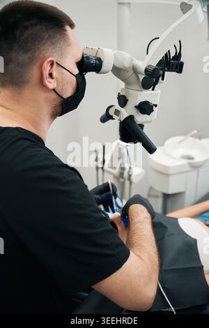 Focused Caucasian man using dental microscope in clinic Stock Photo