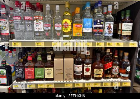 Variety of bottles of spirit drinks (whiskeys, vodkas) on shelves of convenience store Nice, France Stock Photo