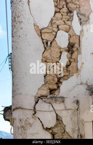 Stone wall of a house with large cracks from an earthquake. Damage to a stone wall with visible stones. Static problem in masonry Stock Photo